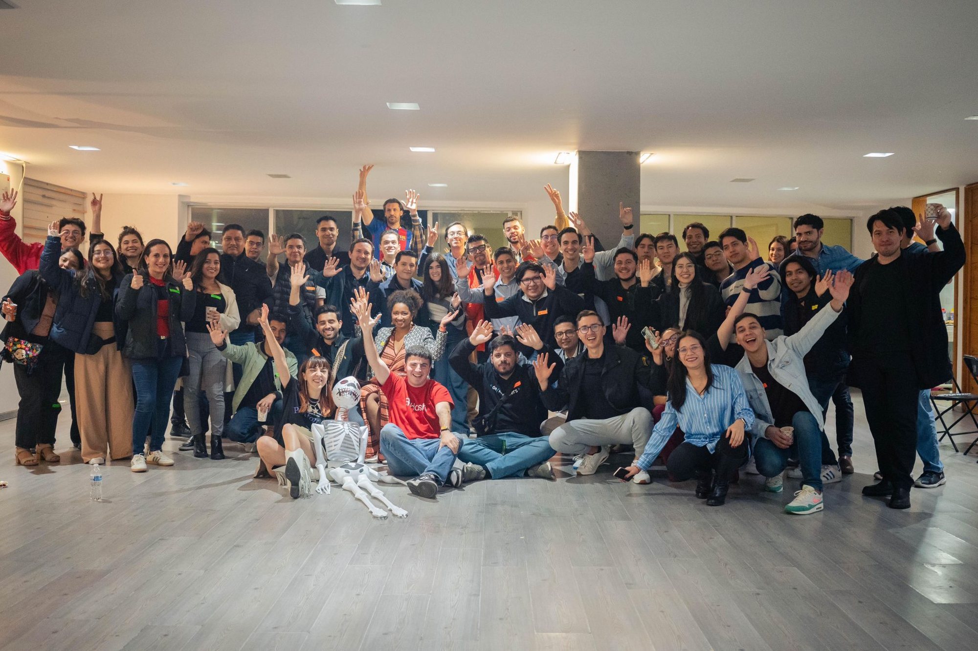Decenas de personas saludando a la cámara al final de un encuentro.